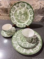 Full set showing dinner plate on stand, second dinner plate, salad plate, cups, saucer