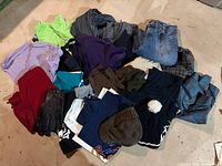 Overall view of pile containing jeans, shirts, gloves, hats