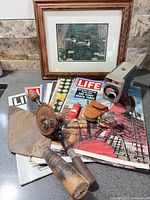 Group shot of framed loon print, Life magazines, 8mm camera, hand tools