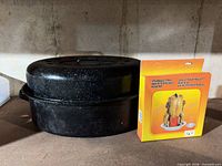 Roasting pan with lid alongside boxed chicken roaster