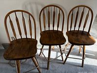 Three wooden bar stools side by side