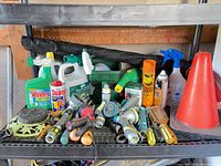 Full shelf showing hose nozzles, sprinklers, chemicals, hand tools