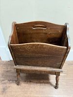 Full view of wooden magazine stand showing dual compartments and leg base