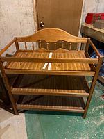 Front view of wooden three-tier baby changing table