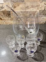 Punch bowl, ladle and six glasses displayed