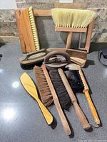 Group of vintage cleaning tools and brushes displayed on countertop