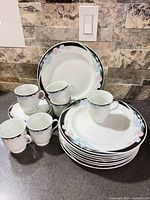 Stack of dinner plates and mugs displaying quantity and pattern