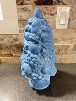 Full view of blue ceramic fruit topiary on counter