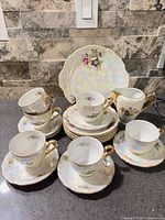 Full grouping of teacups, saucers, plates and creamer
