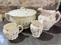 Full view of four matching porcelain wash set pieces