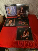 All five record albums laid out on red surface