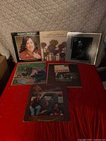 All six vinyl albums laid out together on red surface