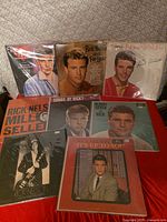 Nine Ricky Nelson LPs arranged in two rows showing front cover art and protective sleeves