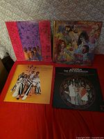 Front covers of four LP albums displayed on red surface
