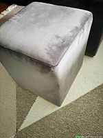 Single gray velvet cube ottoman showing upholstery texture and shape