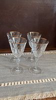 Four cut crystal wine glasses with gold rims on table