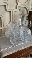 Four clear cut glass barware pieces