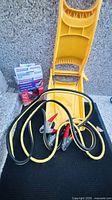 OptiMate 3 charger box, jumper cables, folded yellow shovel