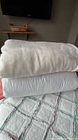 Cream fleece blanket folded atop white duvet insert, queen size