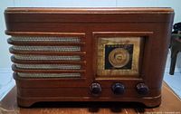 Front view showing grille, dial, knobs, wood finish