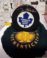 Signed Toronto Maple Leafs puck on green authenticated pouch