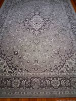 Full view of the gray-beige VEDBÄK rug showing overall pattern and border