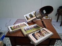 Viewer resting on table with several colour stereograph cards displayed