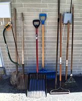Group view of all eight long-handled tools lined against wall