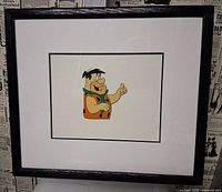 Front view of framed animation cel showing Fred Flintstone image within mat and frame