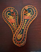 Top view of both painted wooden paduka sandals showing bird motifs and toe knobs