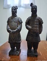 Front view of both ceramic Terracotta Army figurines showing armor detail and coloration
