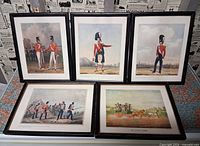 Group shot of all five framed prints upright on display