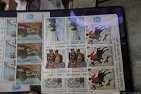 Two overlapping souvenir sheets, left with rural landscape stamps, right with art and horseback rider stamps