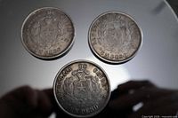 Three silver-plated replica Chile Un Peso coins