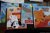 Front covers of five Disney Wonderful World of Reading hardcovers: Peter Pan, 101 Dalmatians, Dumbo, Winnie the Pooh, plus partial additional title