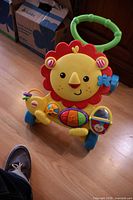 Full view of Fisher-Price lion walker showing handle, wheels and activity center