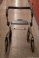 Front view showing frame, seat, wheels, handles and brake cables