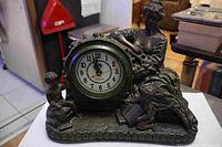 Front view of the French style mantel clock showing dial and full sculpture