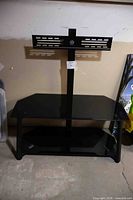 Full view of TV stand showing glass shelves and metal mount