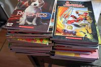 Two stacks of assorted Scholastic children’s paperback books