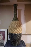 Full view of tall wicker vase showing shape and tri-color bands