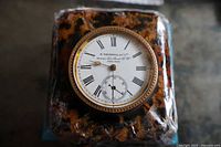 Front view showing dial, bezel, faux tortoiseshell case