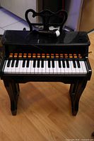 Full view of black children’s electronic piano with microphone on top