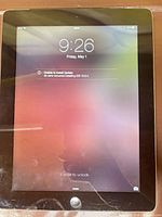 Front view of iPad powered on showing lock screen at 9:26 AM