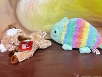 Rainbow chameleon and Paisley goat plush side by side showing size, coloration, and goat hang tag