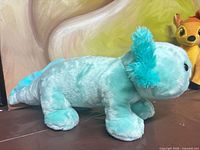 Side profile of mint green axolotl plush showing full body, tail, limb structure, color