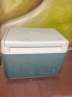 Front view of green Coleman cooler with white lid closed