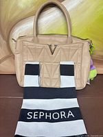 Front view of Crossi New York quilted satchel with Sephora tote draped