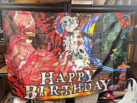 Full view of Demon Slayer Happy Birthday vinyl banner hung on shelving