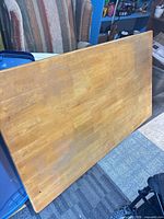 Top view of rectangular solid wood table top showing natural finish and wear